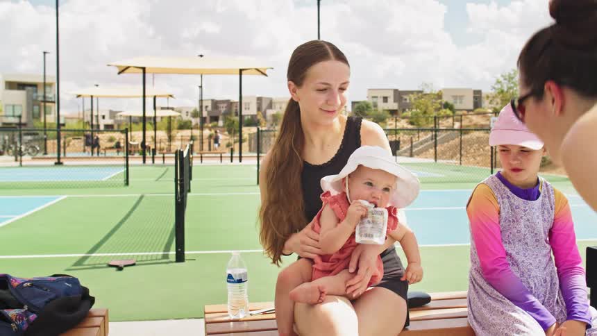 The family sit together in the tennis court