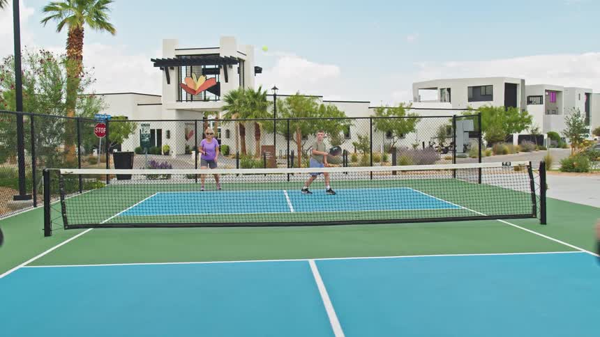 Woman hits a ball during a pickleball game in a residential area