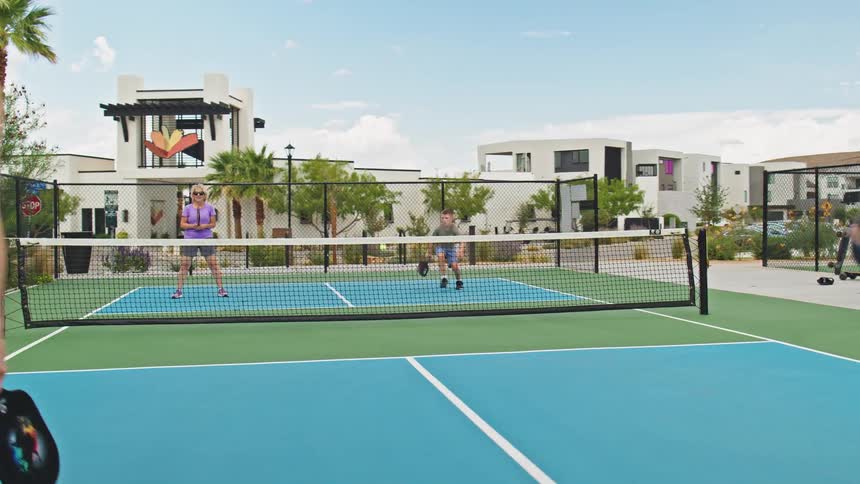 The woman serves the pickleball