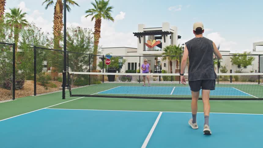 People run towards the net while playing pickleball