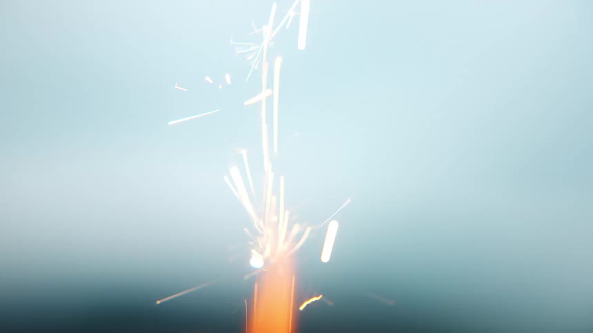 Fireworks ignite outdoors their flames bursting to life and scattering bright sparks into the air