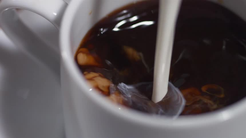 Cream splashing into a cup of coffee