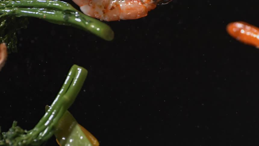 A bunch of food flies in a dark area