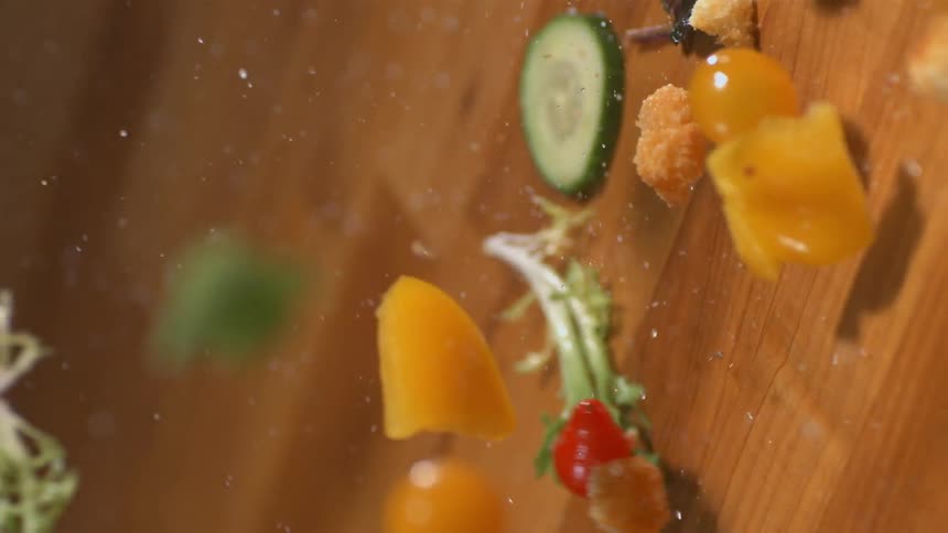 Vegetables fall onto a wood surface