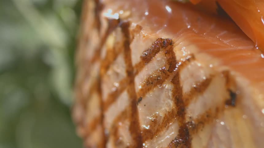 A fluid is drizzled over a piece of seared meat