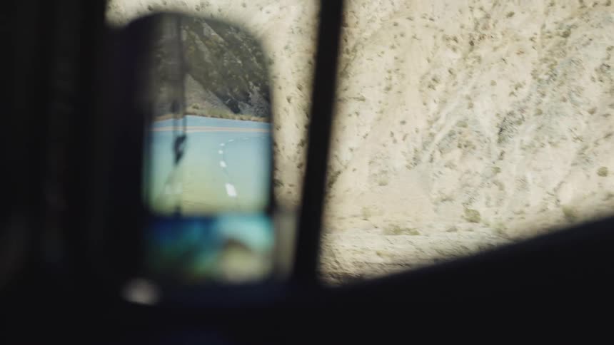 A van drives on a mountain freeway on a sunny day