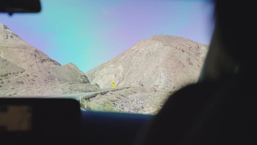 The vehicles travel on the highway through the mountains