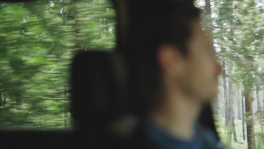 Man sitting inside a car looking out the window during the ride