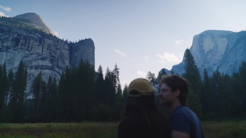 The couple hug in front of the national park