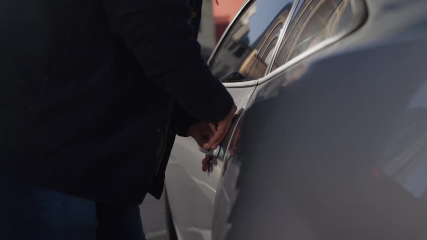 The man unlocks the car and gets in