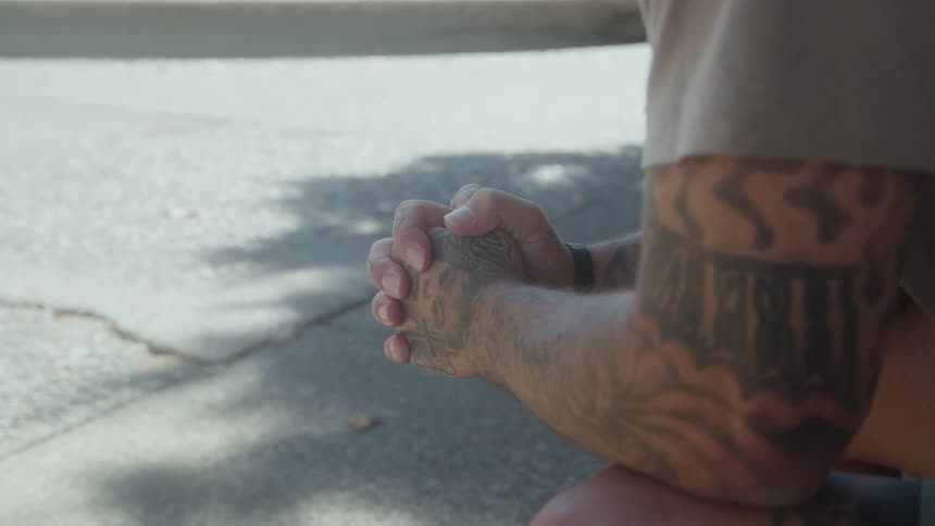 Close up of the heavily tattooed arm of a person sitting outdoors