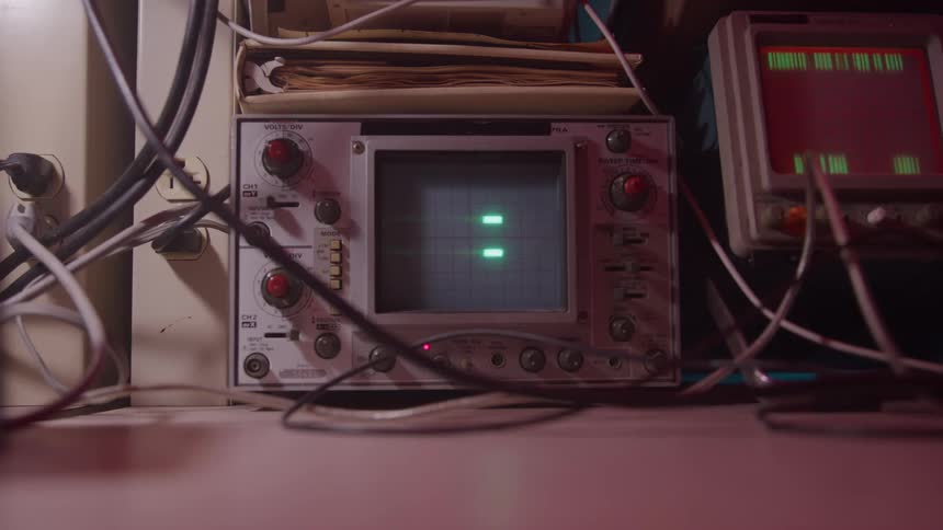 An analog oscilloscope medical device displays green lines