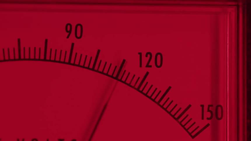 A close up of a red analog gauge showing numbers from 90 to 150