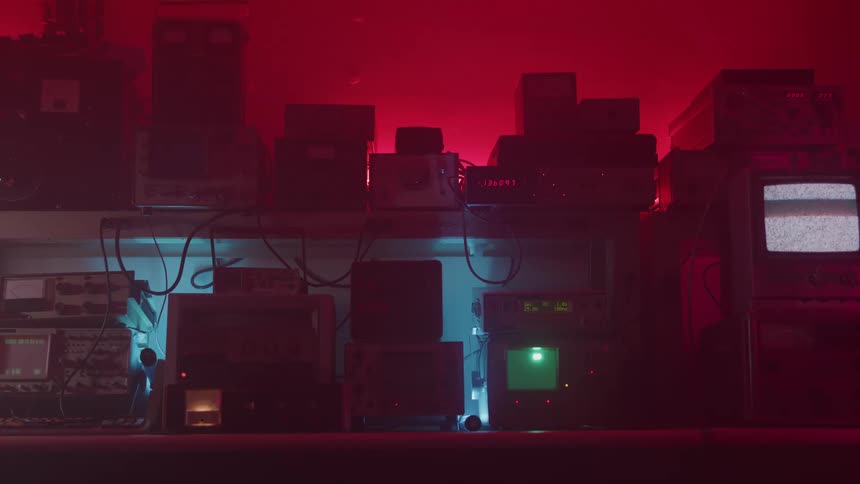 Set of vintage electronic devices and monitors illuminated by red and blue light