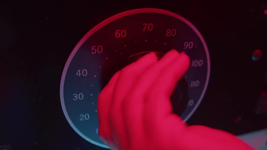 Adult male hand dialing a button on a machine indoors