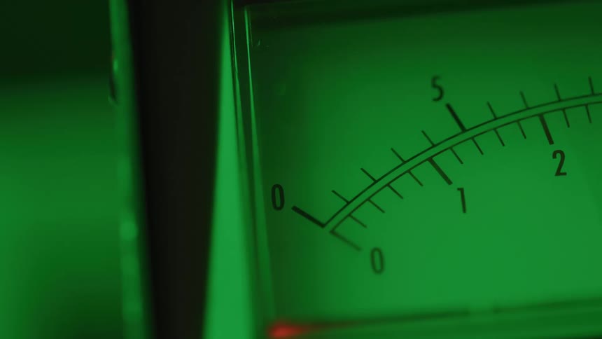 Analog gauge needle indicates a reading under bright green light