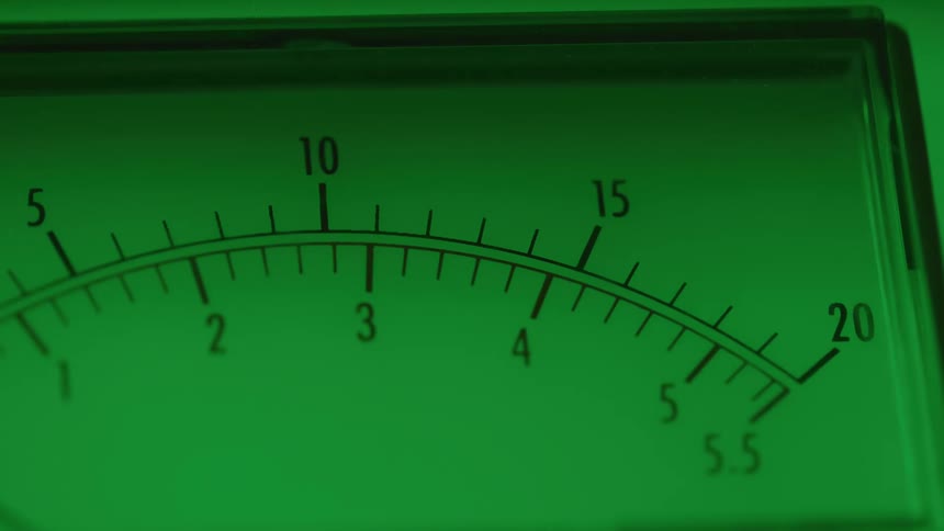 Green lighting tints an analog display as the needle flips back and forth
