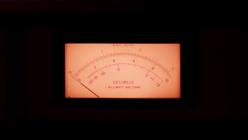 Analog meter displays decibel levels illuminated in orange tone