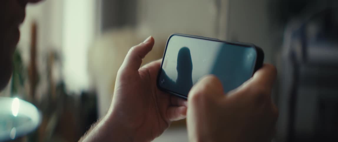The man is swiping on his cell phone