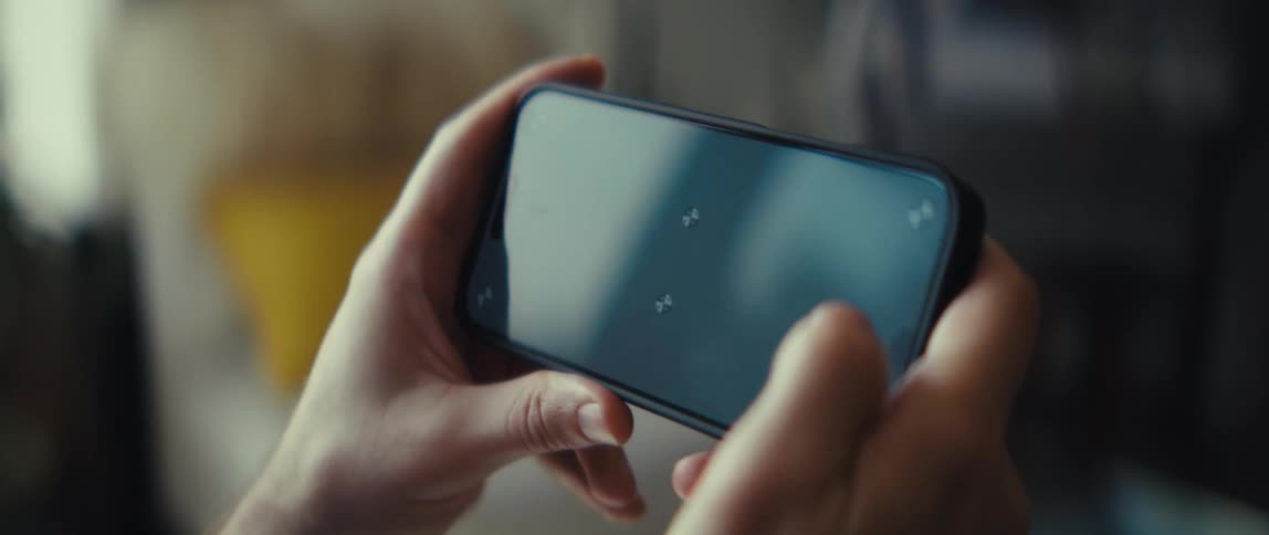 The person uses their thumbs to tap on the cell phone