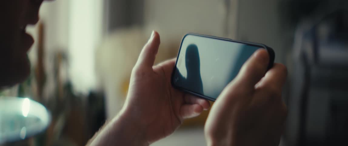 The person holds his cell phone with two hands