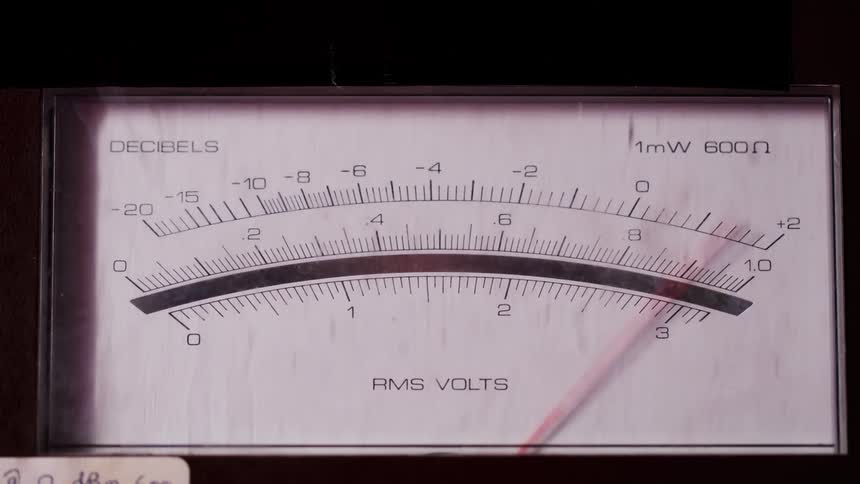 Analog meter needle showing a negative reading on decibel and rms voltage scales