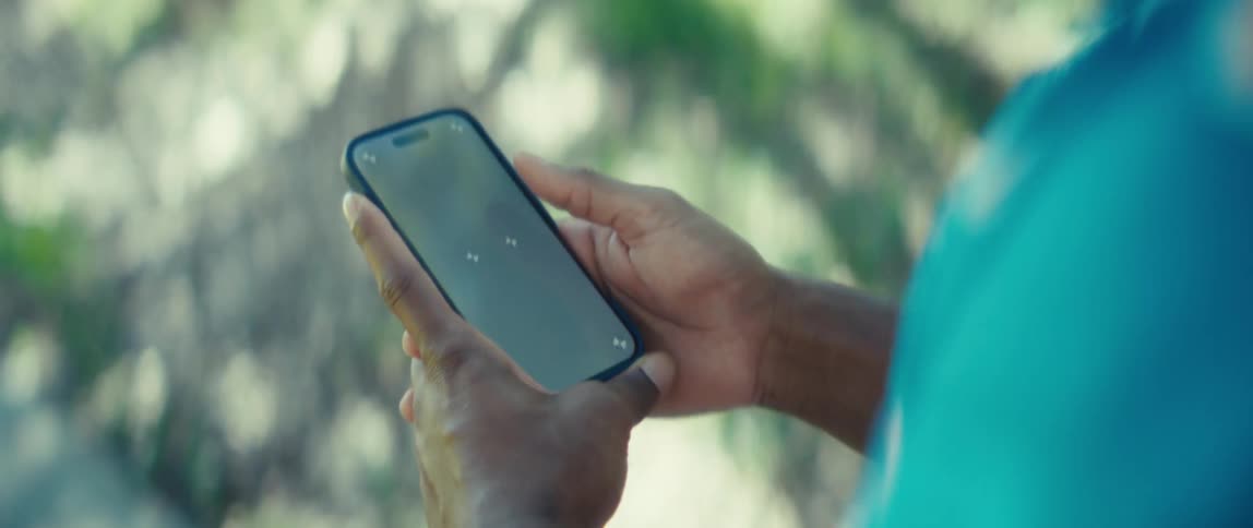 Person interacts with minimalist interface on smartphone while walking outdoors