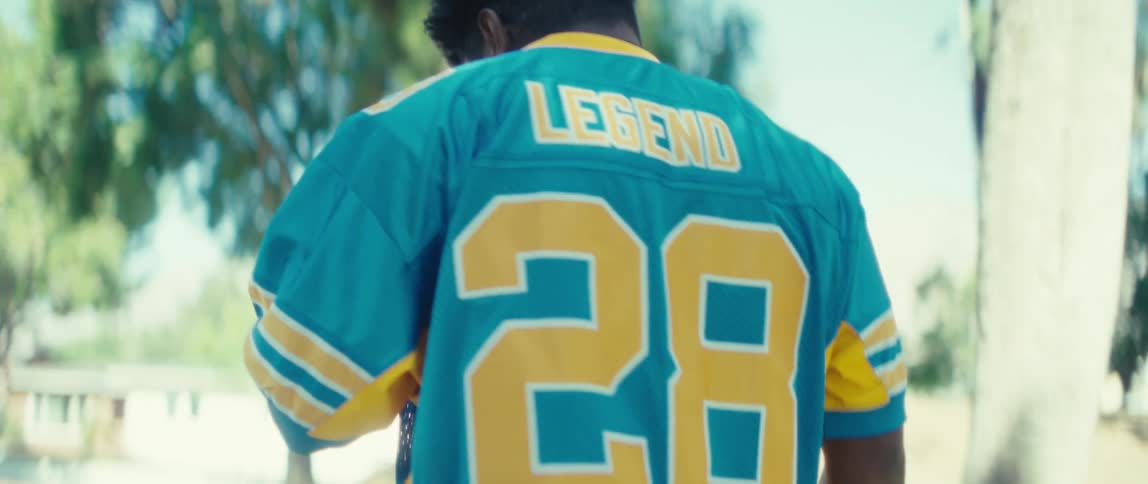 Player raises his arm wearing a sports jersey labeled legend