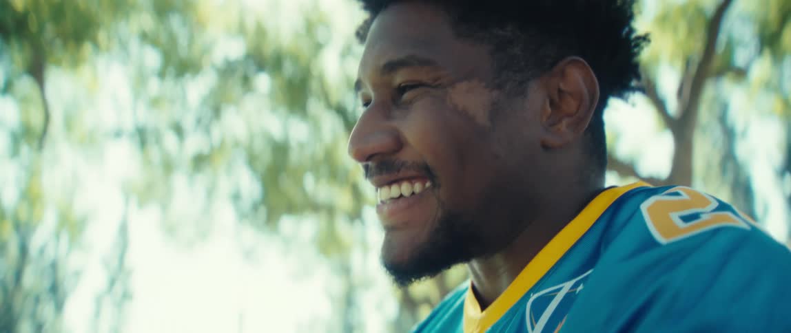 A man is crying and smiling as he talks on a cellphone outside