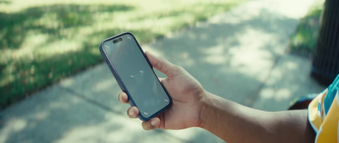 A man is standing outside on a sidewalk looking at his phone