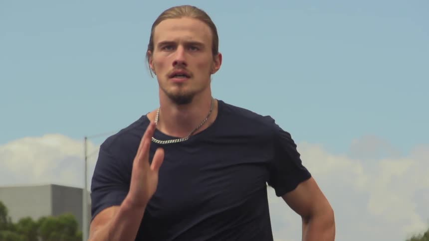 A young man with long, blonde hair running in slow motion