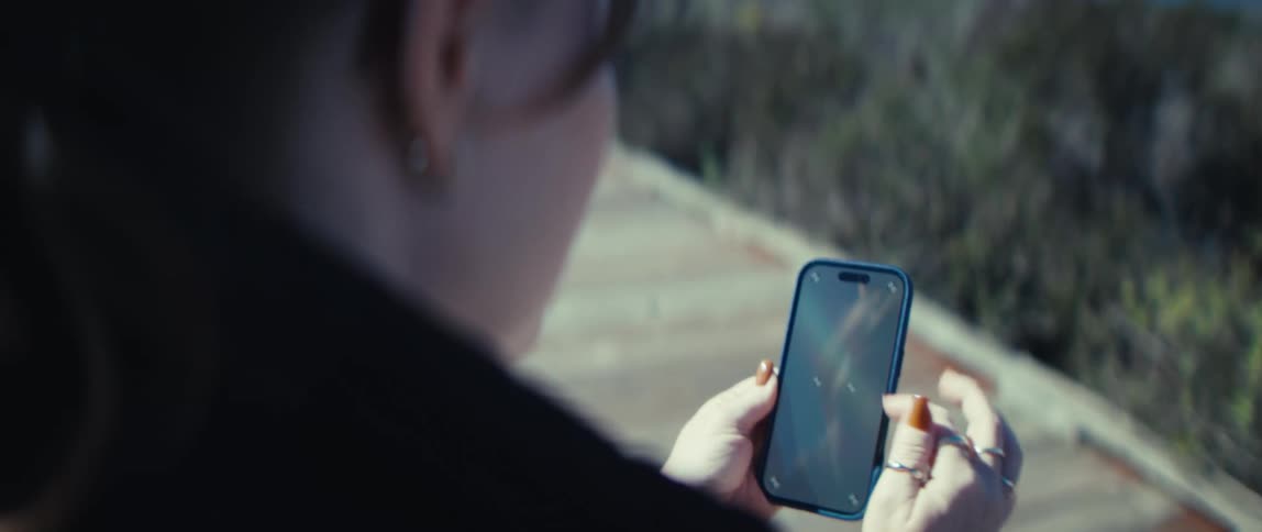The woman is tapping on her cell phone screen