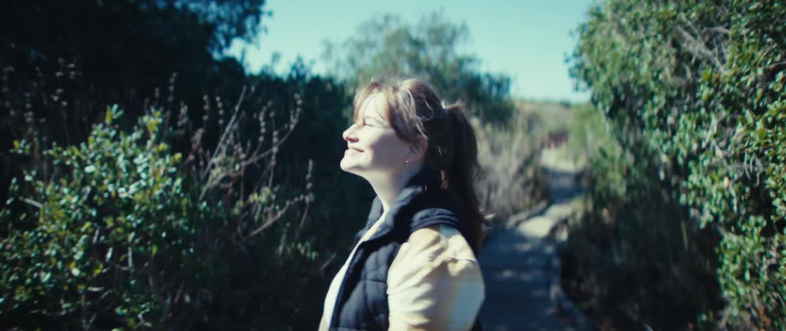 A young woman walking happily along a rocky trail outdoors