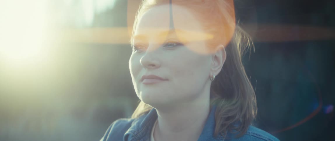 Woman gazes at the horizon bathed in sunlight