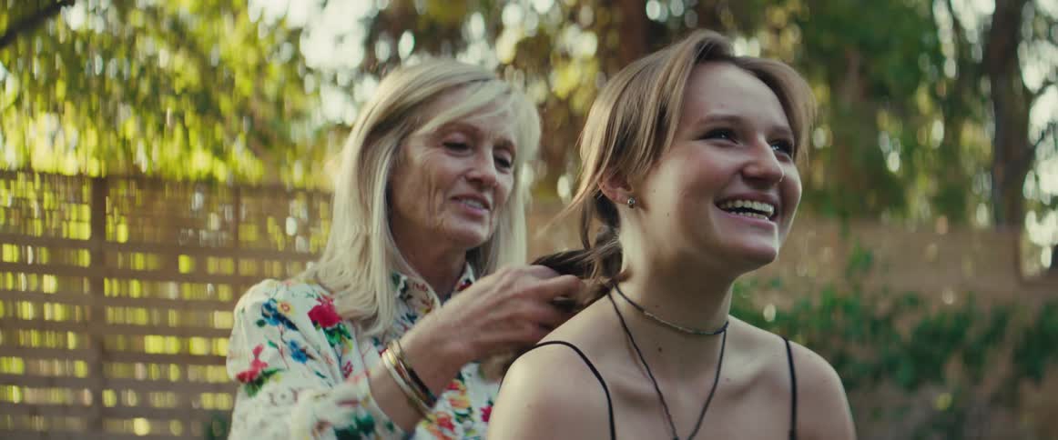 The woman braids a teenagers hair