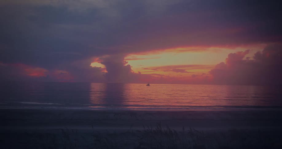 The sun is rising on the beach