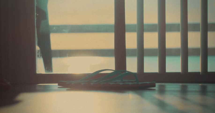Feet move in blue flipflops under the soft light of dusk