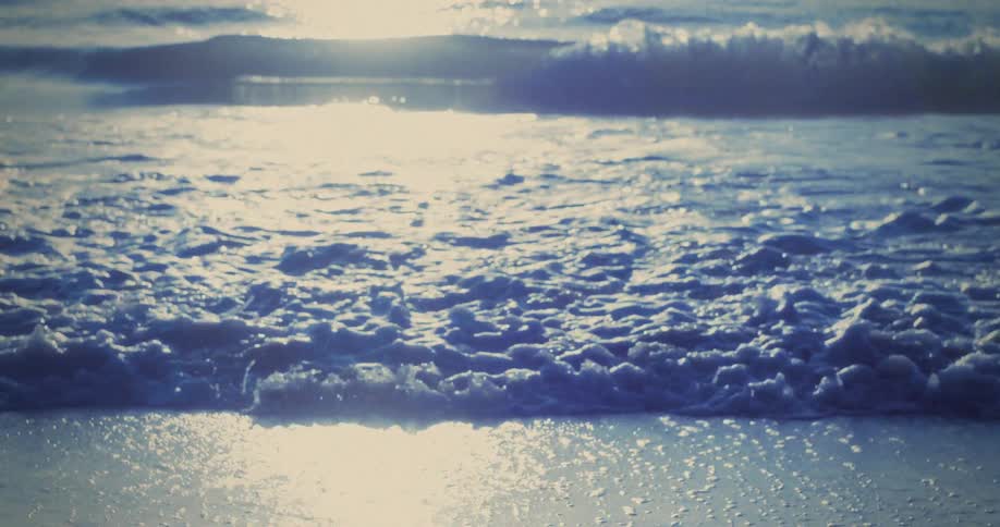 Gentle waves reflect the bluish sunlight on the sea surface