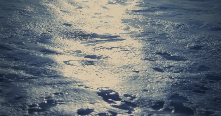 Sunlight shines on rough water as it ripples and waves