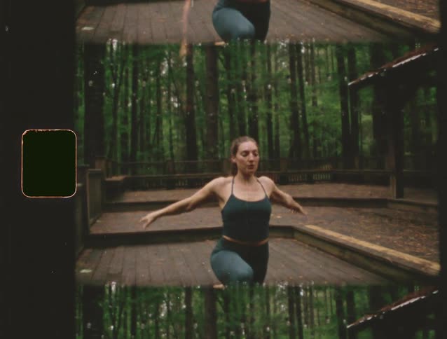 Woman performs yoga while on a deck in the forest on a summer day