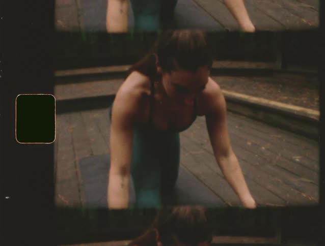 A woman in a dark tank top and workout leggings performs a slow dynamic movement on a wooden surface in a forest setting possibly doing yoga or a functional exercise the video features a vertical film strip effect with multiple mirrored images and a vi