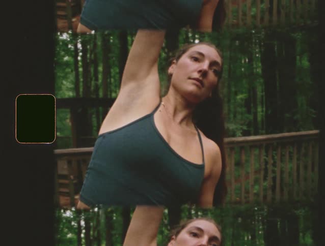 Woman practices stretching outdoors surrounded by trees