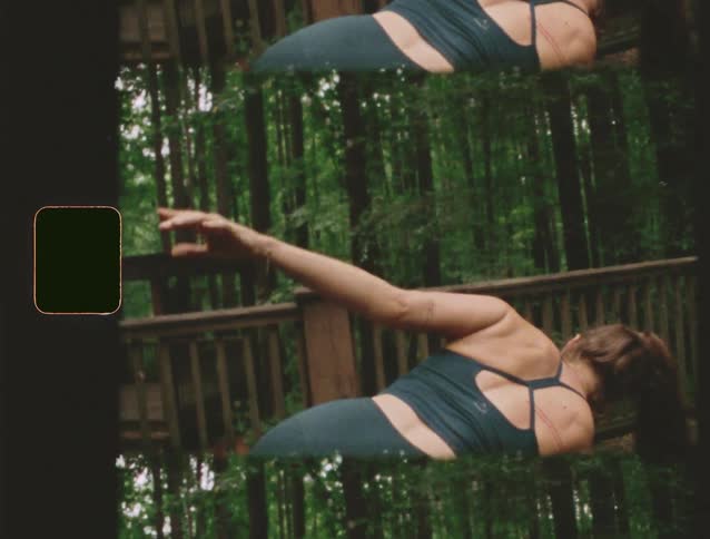 A young woman practices yoga outdoors in the woods at midday