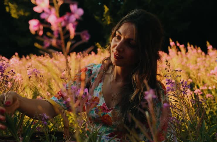 A woman in the tall grass at sunset