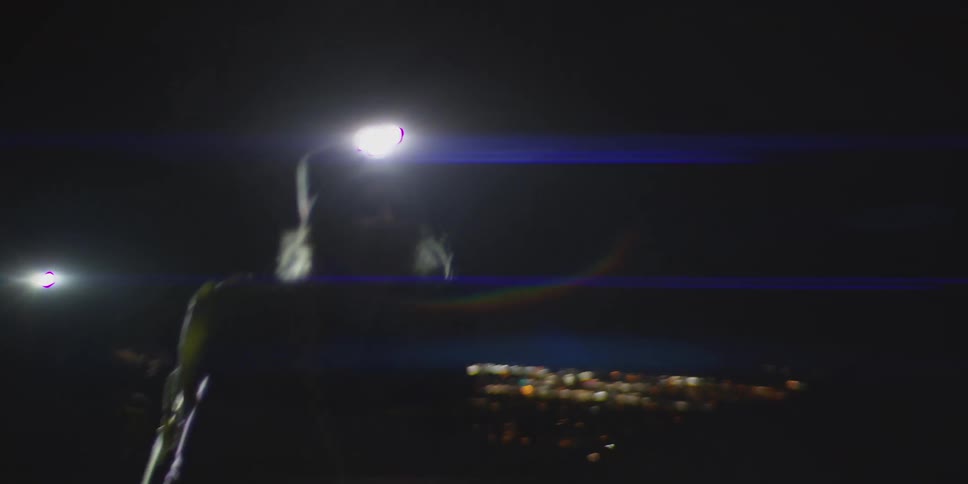 A young woman hikes at night wearing a headmounted flashlight