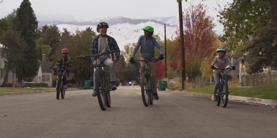 Children ride bicycles side by side on the road