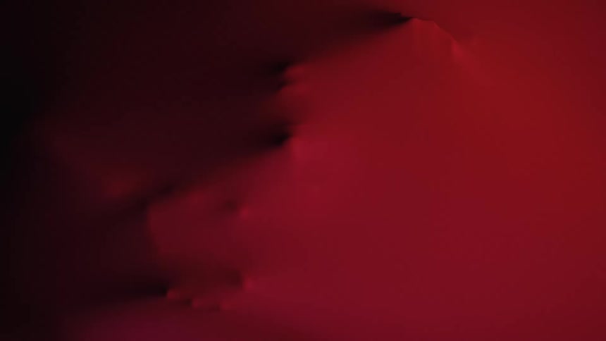 Red surface with dark protrusions in an abstract and illuminated composition