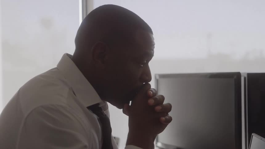 The man is thinking at his desk