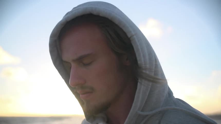 Man walking by the shore at sunrise