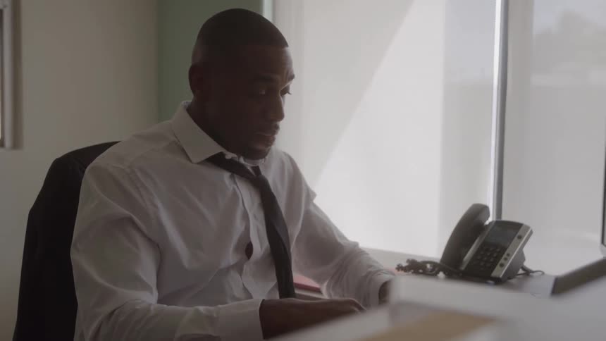 Man working in his office removes his headset and tiredly rubs his eyes